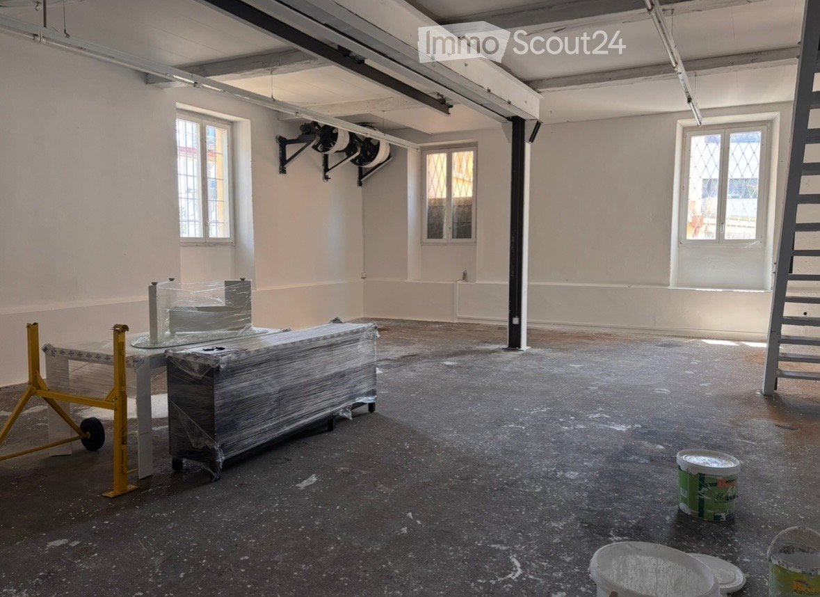 Empty room with bare walls, concrete floor, and windows. No furniture or equipment present.