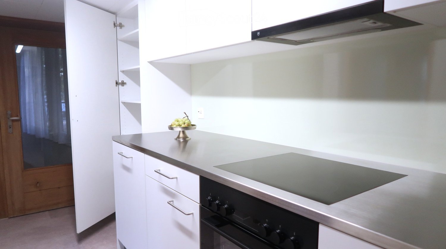 Modern kitchen with white cabinets, stainless steel appliances, and a sleek countertop.