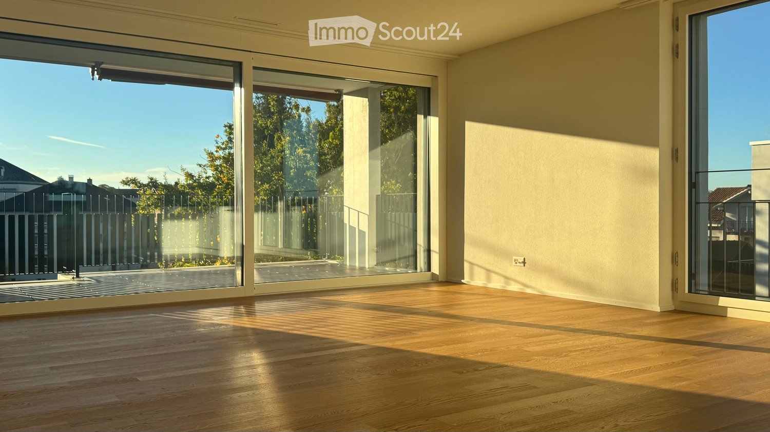 Empty room with wooden flooring and large glass sliding doors leading to an outdoor area.
