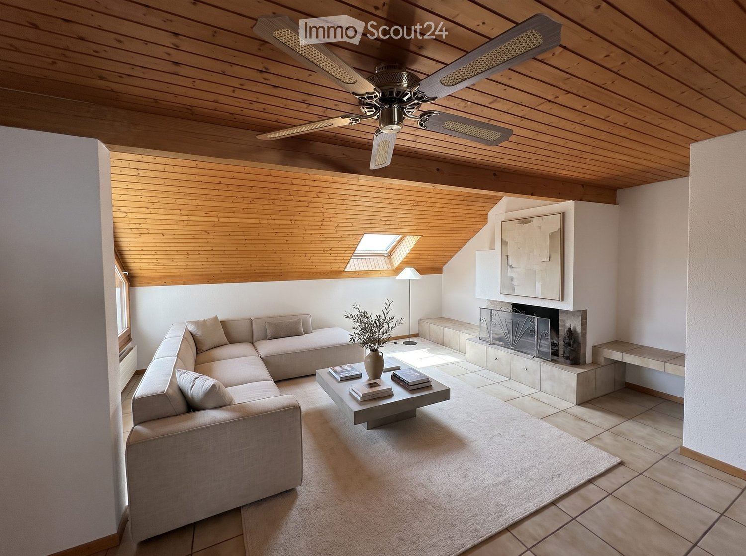 Modern living room with a sectional sofa, coffee table, fireplace, and skylight. Features wooden ceiling beams and a ceiling fan.