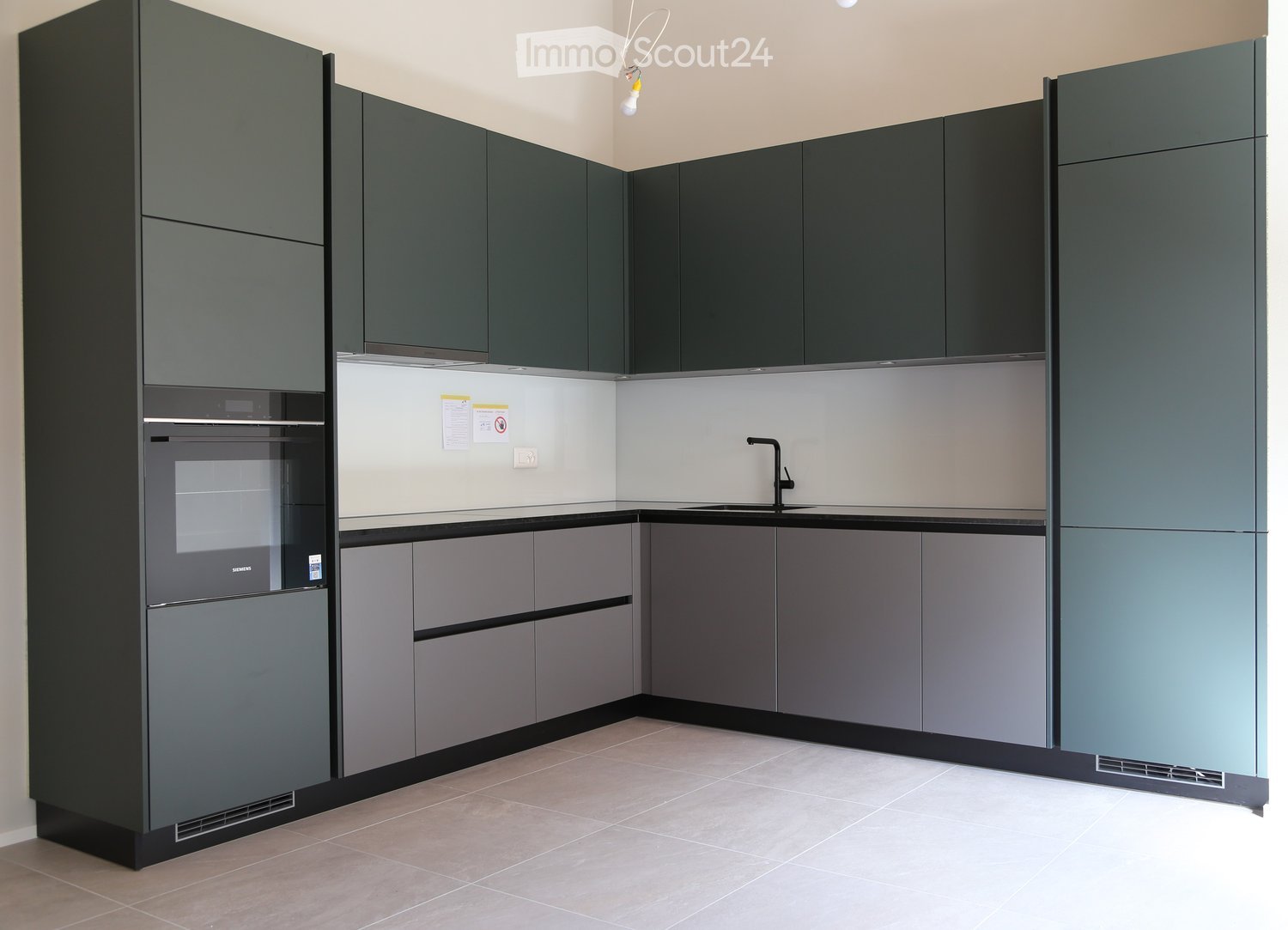 Modern kitchen with grey cabinets, stainless steel appliances, and a clean, minimalist design.