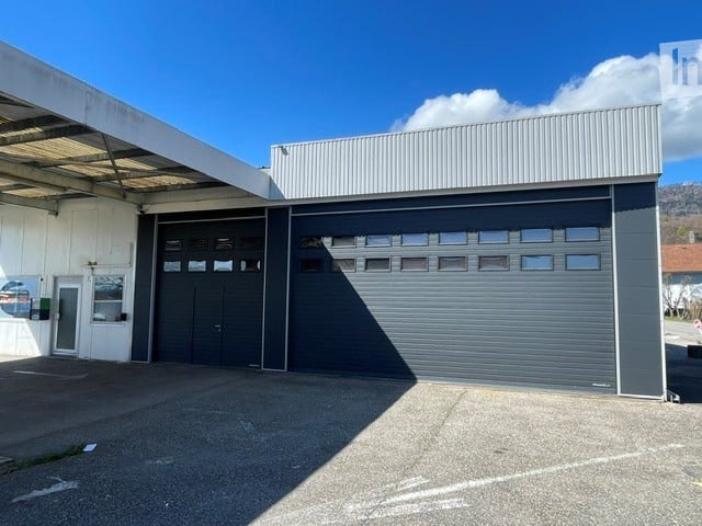 Industrial-style building with large garage doors and a covered entrance area.