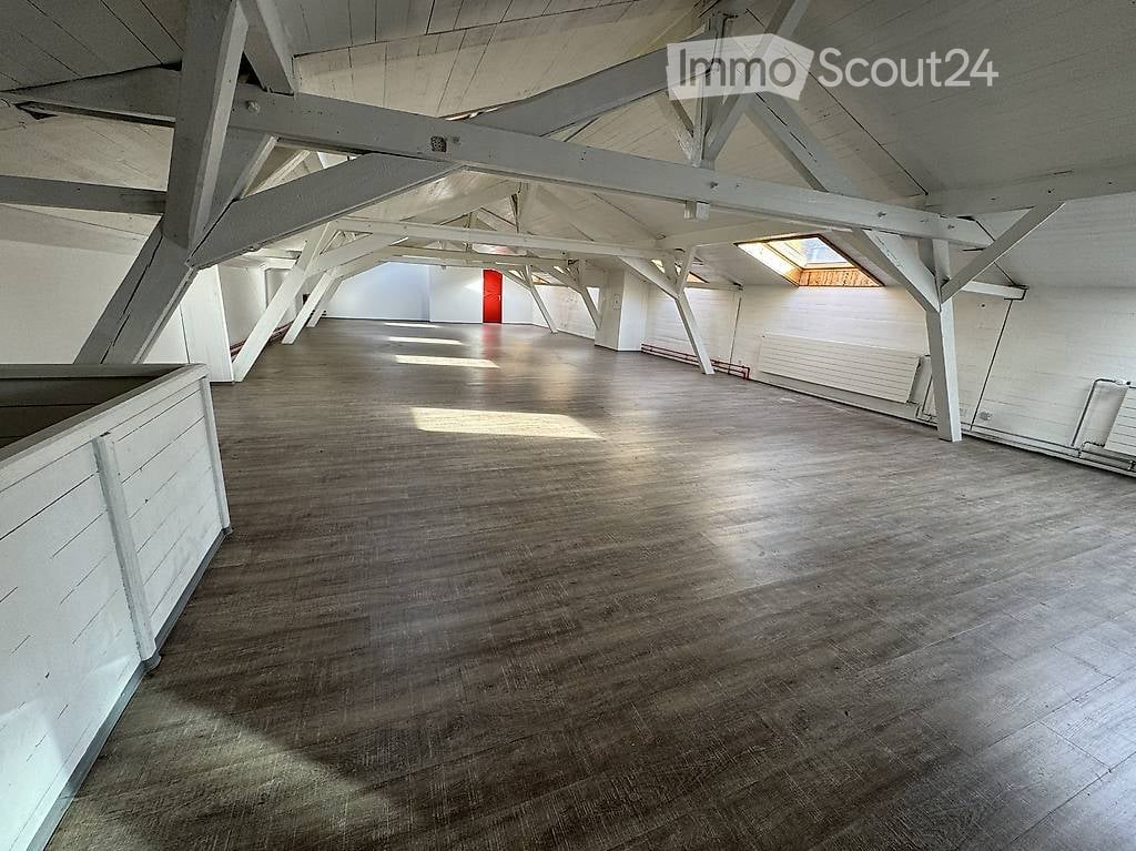 Empty room with wooden floor and white wooden beams on the ceiling. No furniture or equipment.