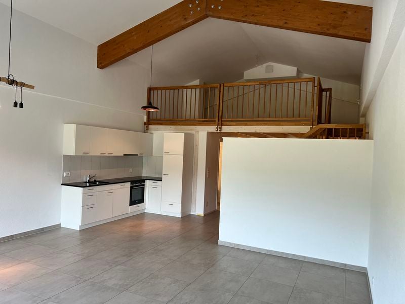 White cabinets, modern kitchen, black countertops, modern oven, sink with faucet, raised ground floor with wooden beams, wooden balcony, tiled floor