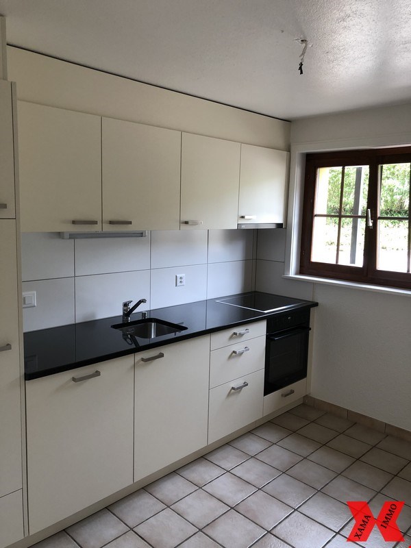 Modern kitchen, white cabinets, black countertops, white tiles, double sink, gas stove, electric oven, double power outlet