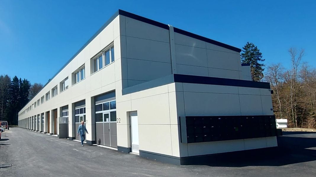 modern building, multiple garages, white exterior, glass windows, number 22 on the wall