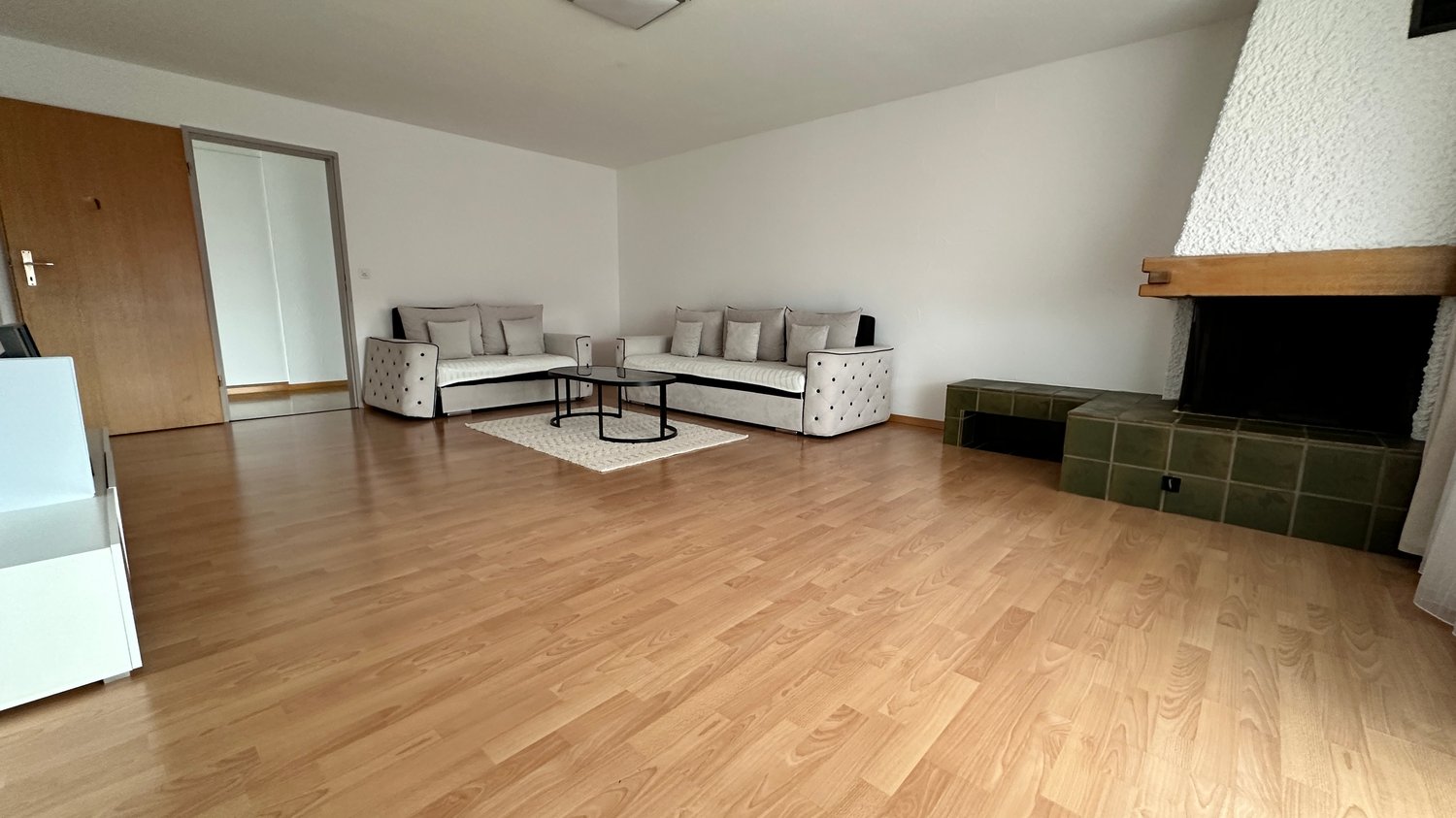 2 sofas, coffee table, rug, fireplace, open door