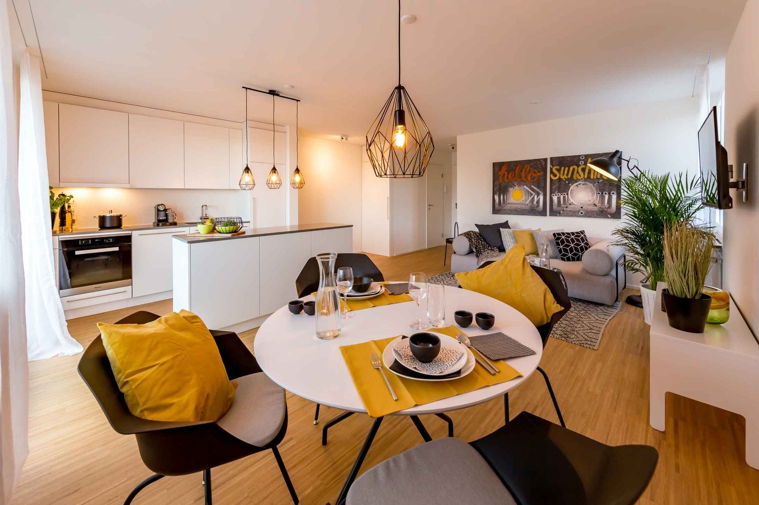 modern design, open concept, white kitchen with built-in appliances, dining table, yellow accents, beige sofa, artwork on the wall, carpet, plants