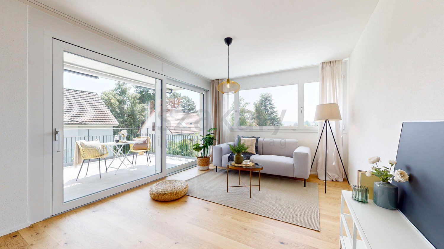 open plan living room, large windows, wooden floor, double sofa bed, balcony, large rug, side table, floor lamp