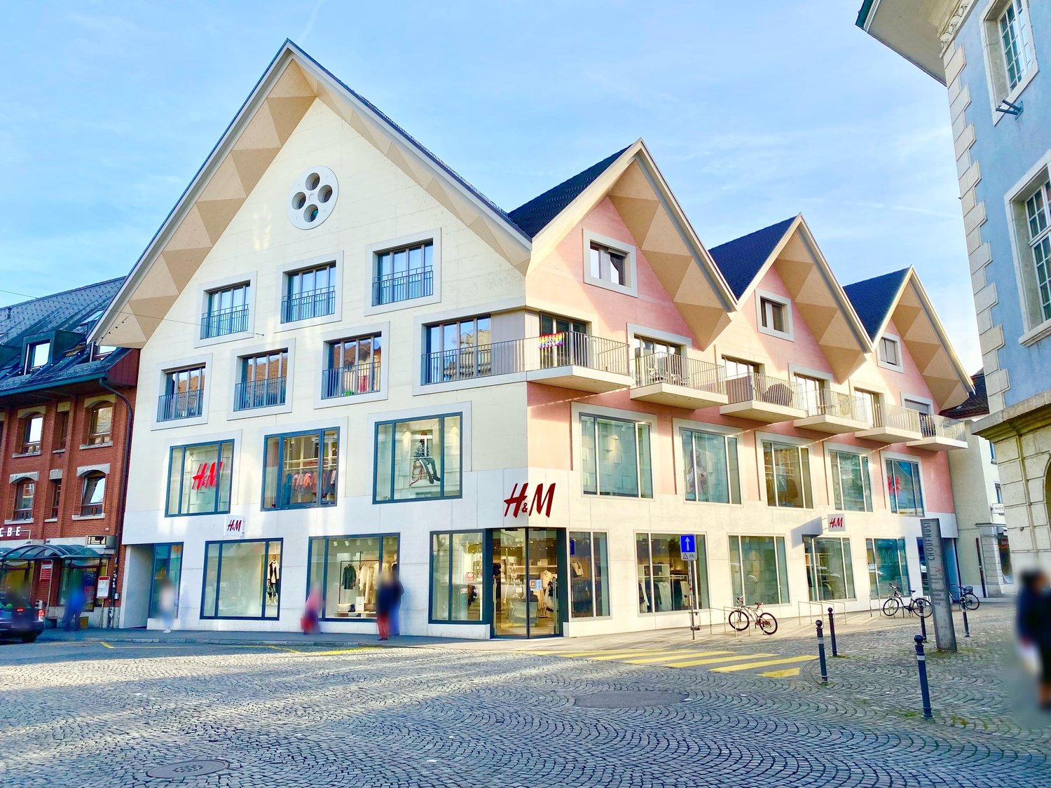 a multi-story building with multiple storefronts and balconies on the upper levels