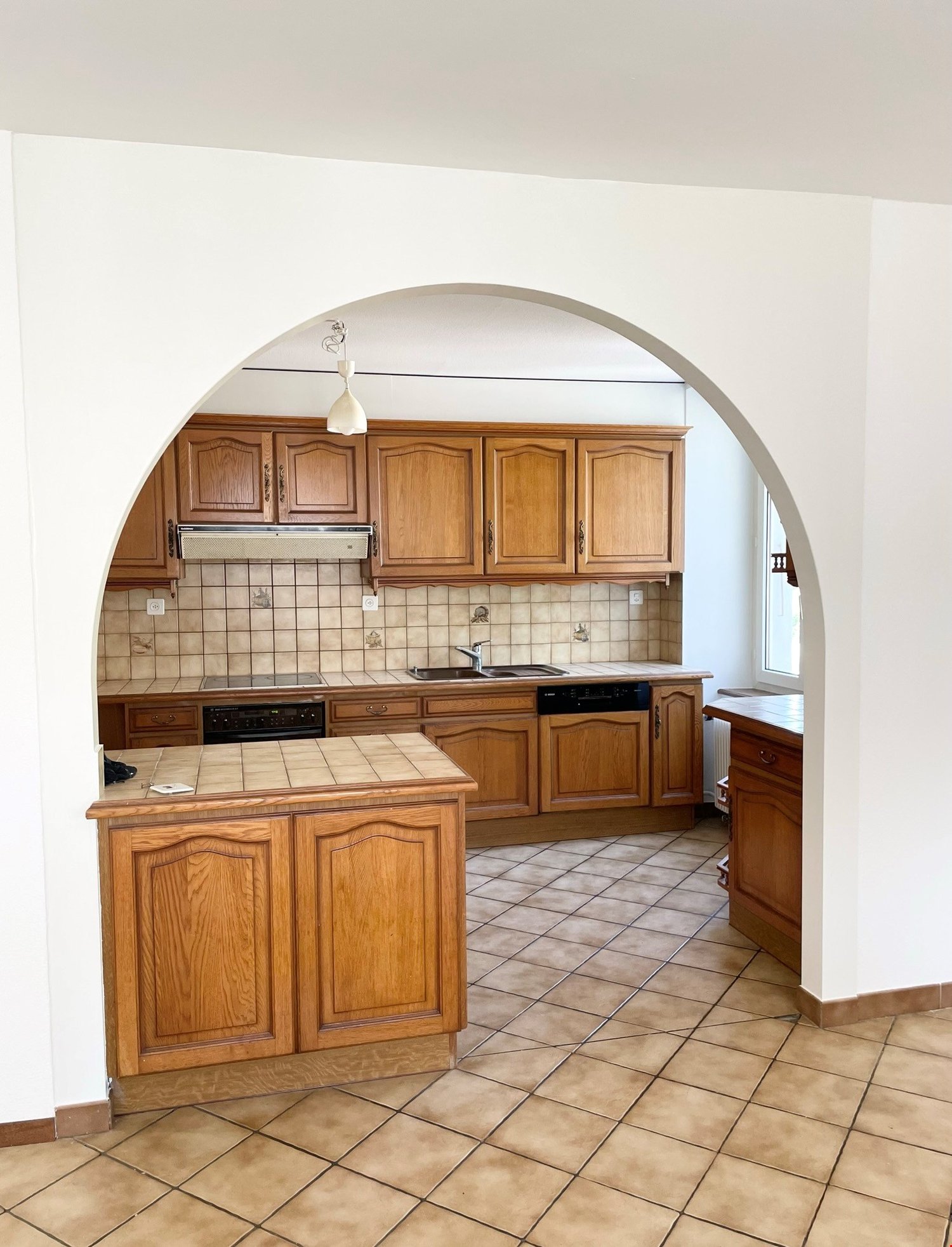 modern kitchen, wooden cabinets, tiled floor, sink, dishwasher, microwave, refrigerator
