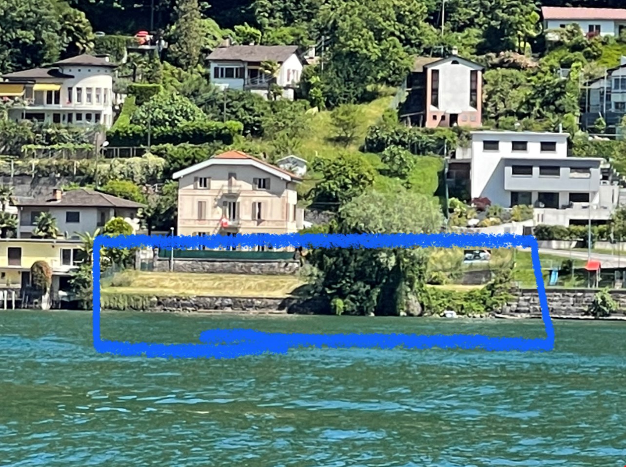 Scenic lakeside town with colorful houses, lush greenery, and a view of the water