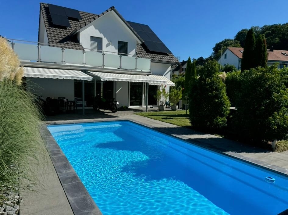 modern single family house, white walls, gray roof, solar panels, swimming pool, garden, motorcycle