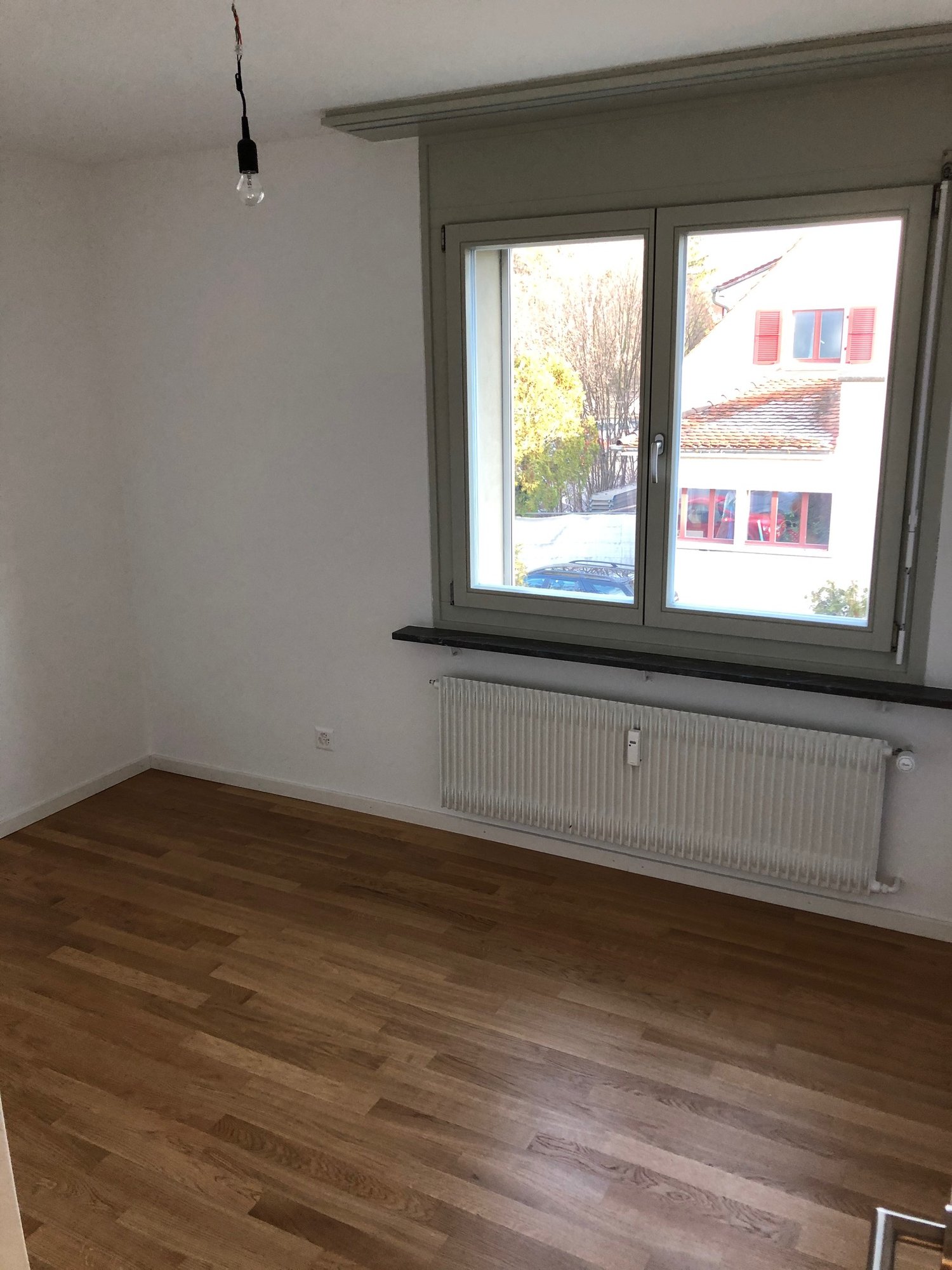 empty room, white walls, wooden floor, white radiator, large window