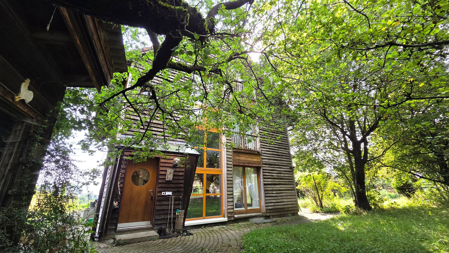 Wooden house, brown door, orange windows, raised ground floor