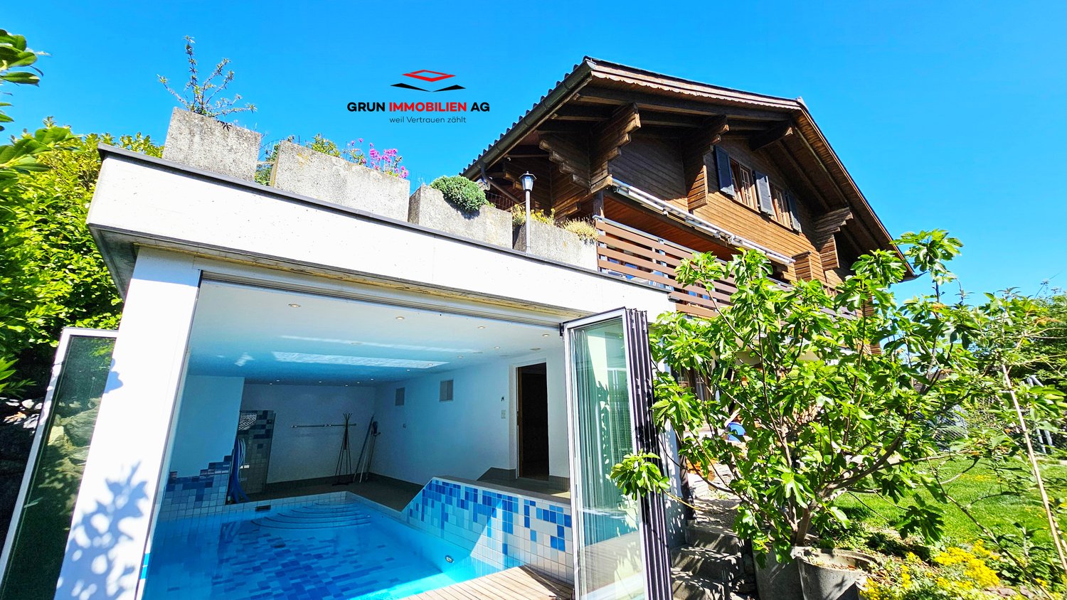 A small building attached to the larger wooden house with an indoor swimming pool