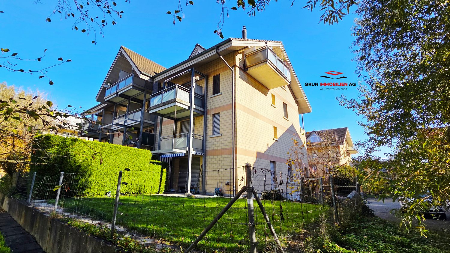 modern house with multiple floors, balconies, and a fenced yard