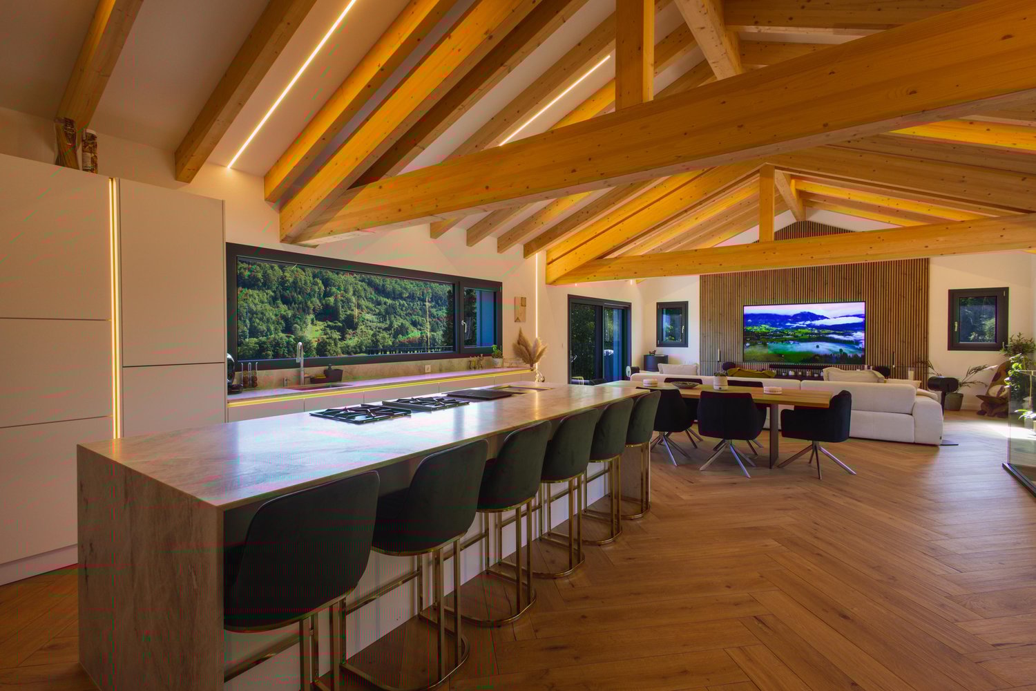 Modern kitchen with large central island, seating area, wooden ceiling, large windows, open-plan living room, large TV, comfortable sofa, dining table and chairs