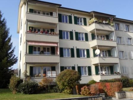 5 story building, white walls, green shutters, multiple balconies