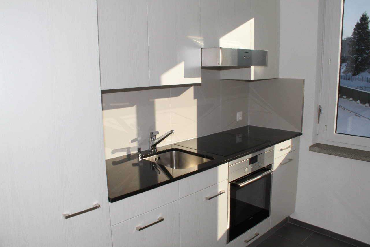 Kitchen: White cabinetry, Black countertops, Stainless steel sink, Modern faucet, Built-in oven and microwave, Large window with outside view