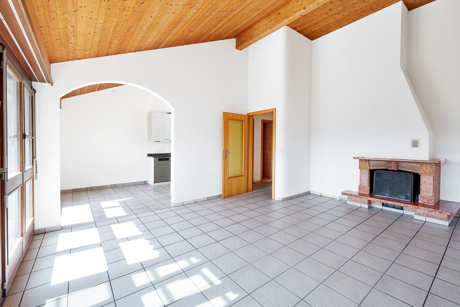 empty room, fireplace, wooden ceiling, glass door, white tiled floor