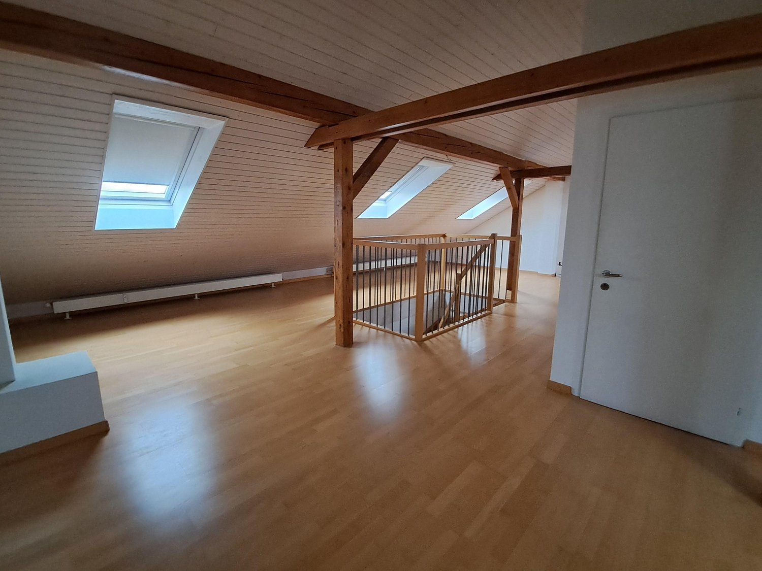empty room, wooden floors, three skylights, wooden railing