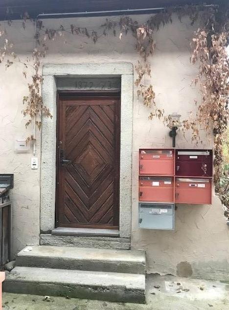 brick wall, wooden door with geometric pattern, mail boxes on wall