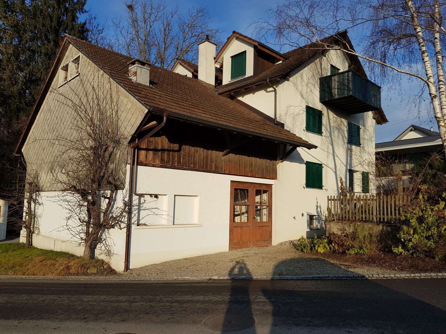 two-story house, brown roof, white walls, brown wooden door, small balcony