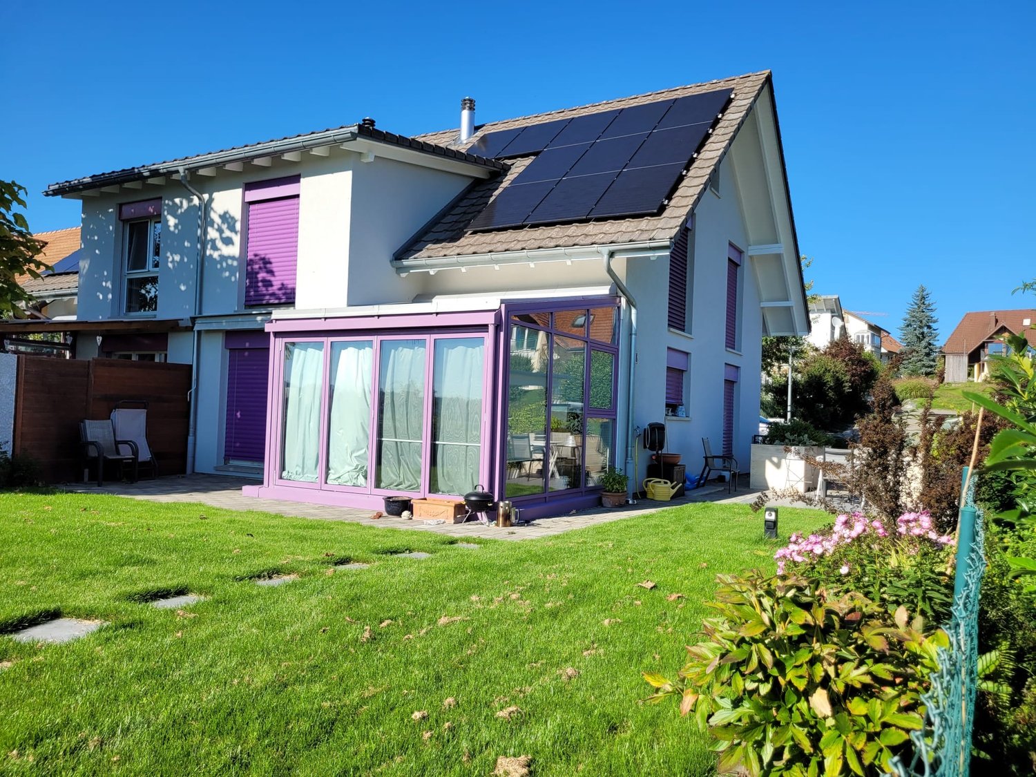 House with solar panels, modern design, purple accents, terrace, garden