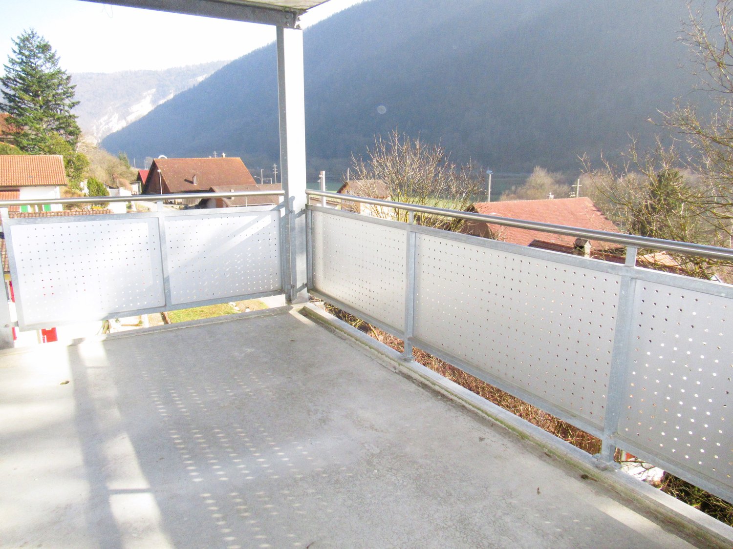 concrete floor, metal railing, view of mountains