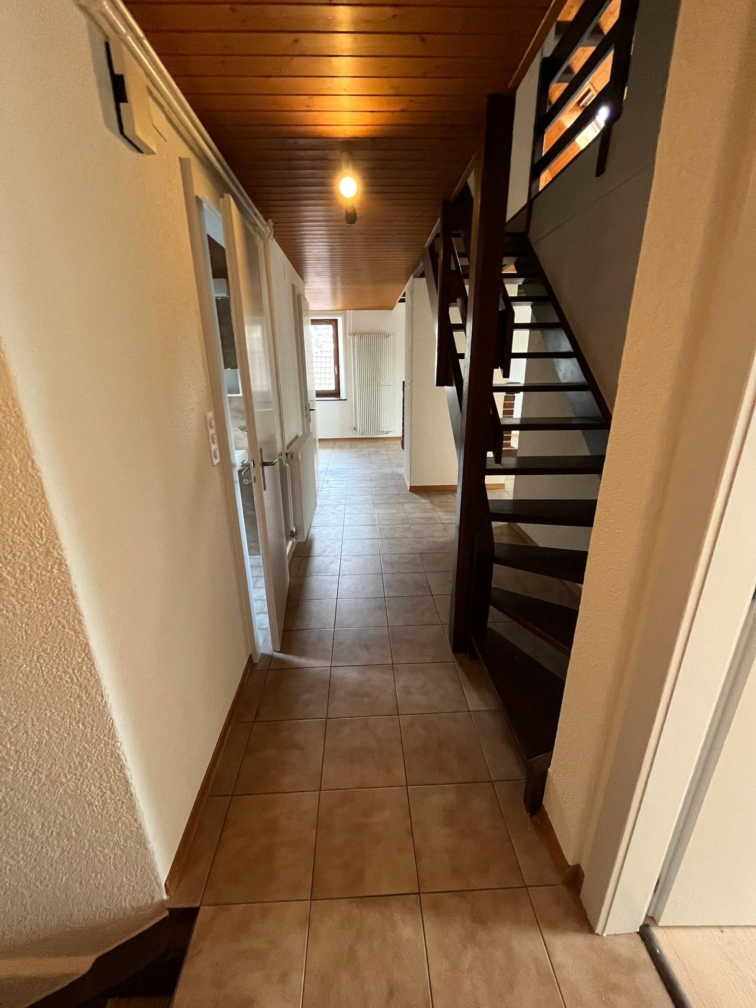 tiled floor, wooden ceiling, light on ceiling, staircase