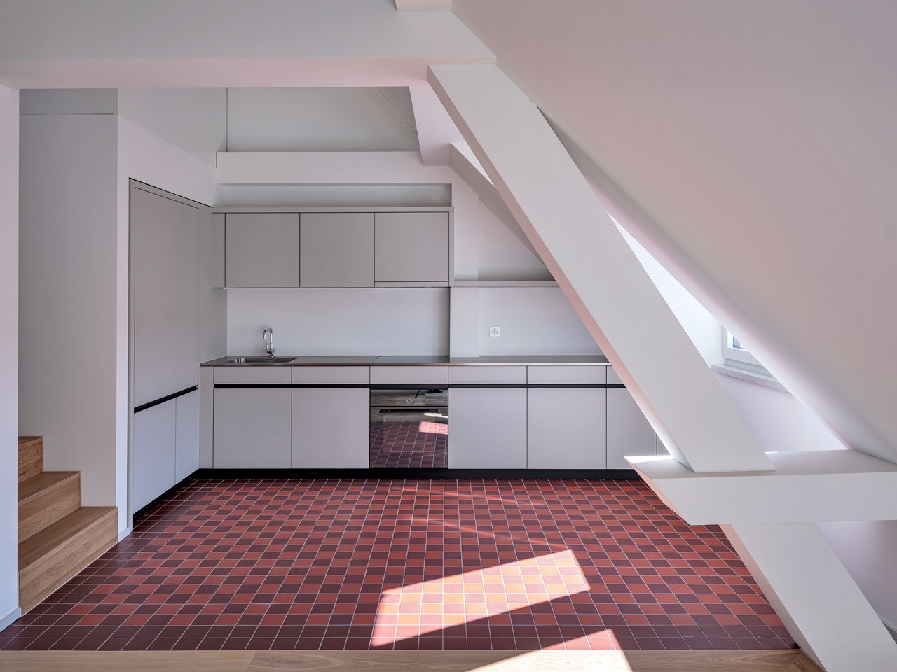Atrium kitchen with wooden beams, tiled floor, white cabinets, stainless steel sink, window