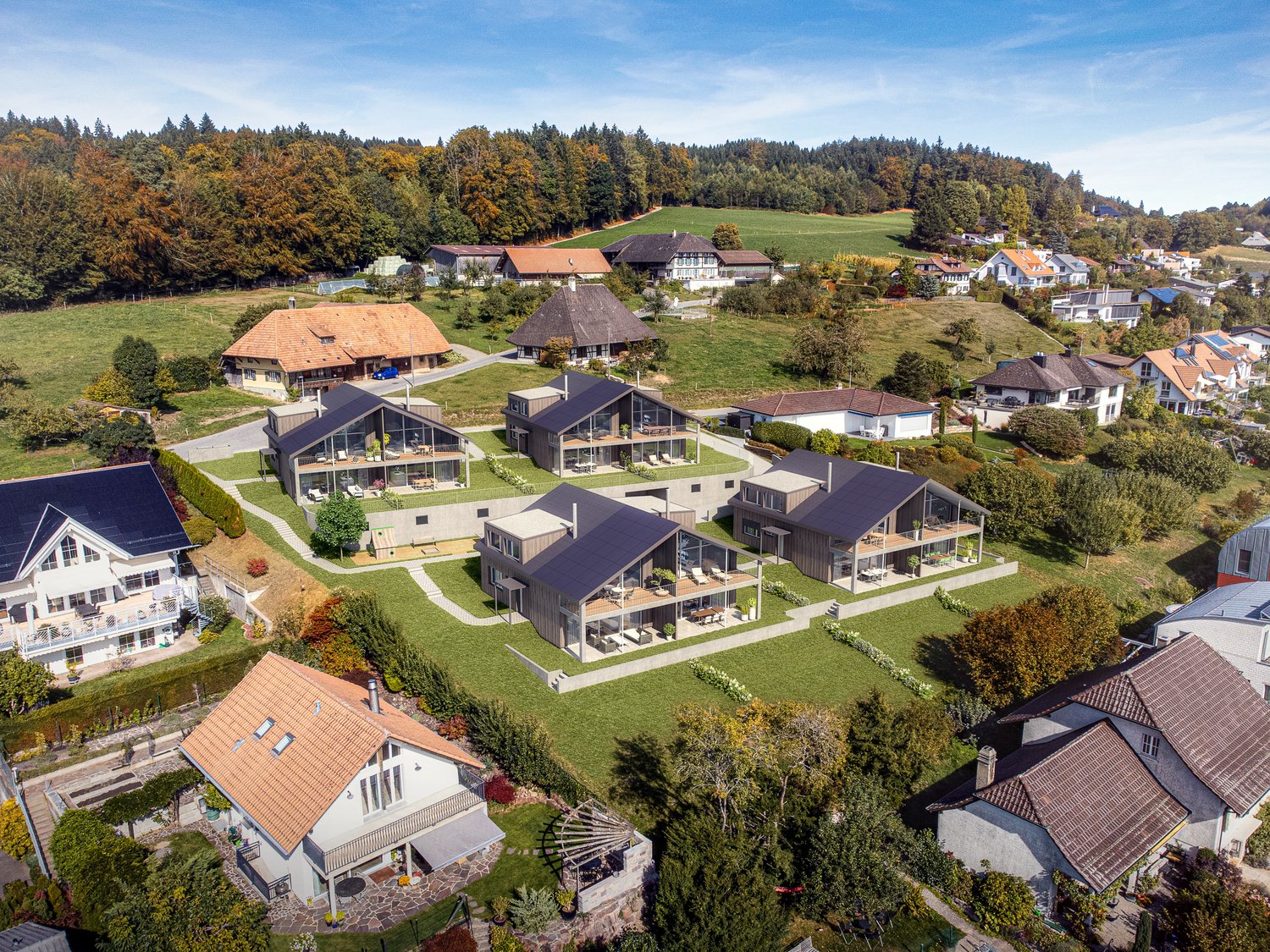 Row of modern houses on a hillside with green fields and trees in the background