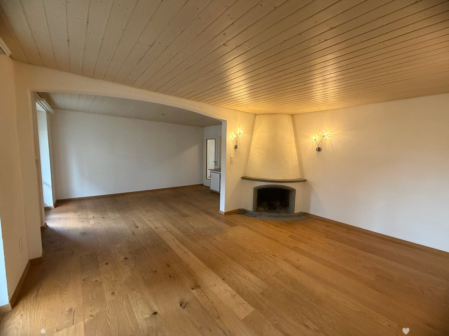 empty room, wooden floor, white walls, fireplace, wall lamps