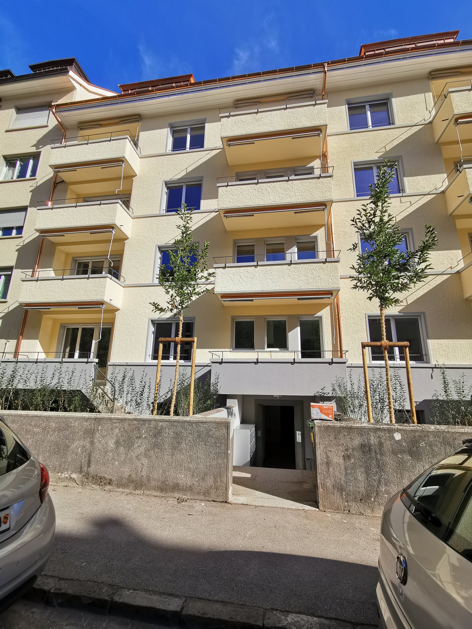 Apartment building with beige exterior walls and red railings on balconies