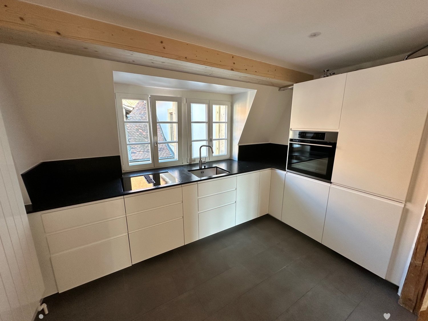 modern kitchen, black countertops, white cabinets, stainless steel appliances, windows