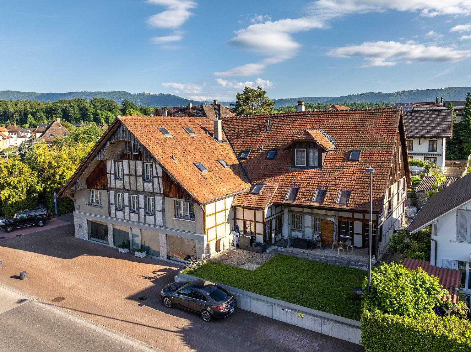 Detached house, large red roof, garage, driveway, mountain views