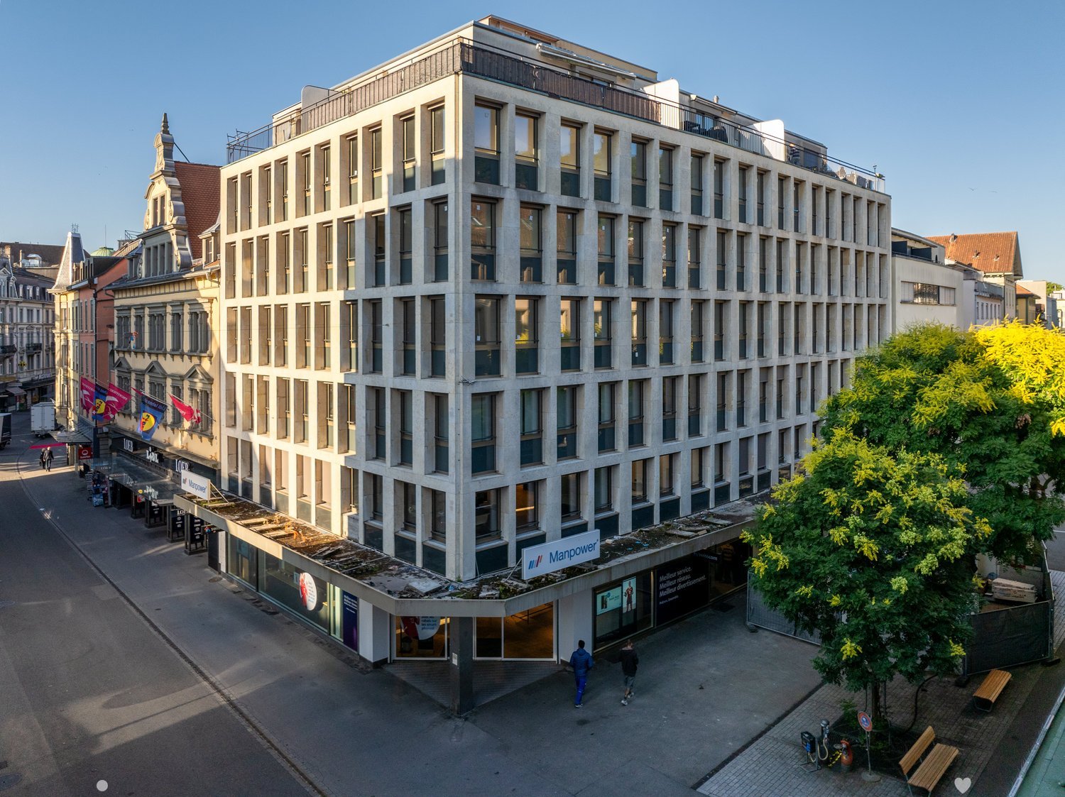 modern building with concrete design, glass windows, metal awning, signboard