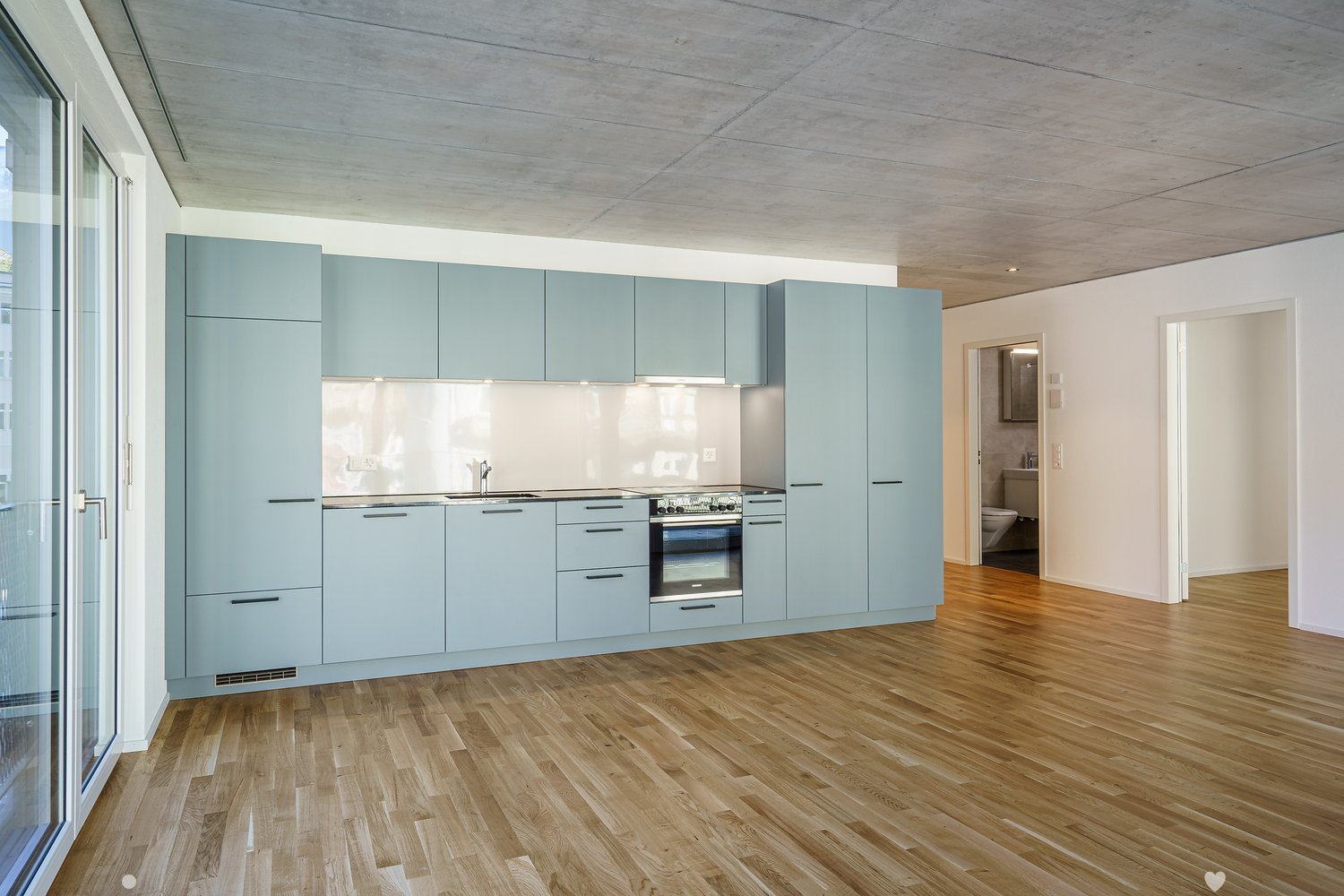 empty kitchen with modern design, light blue cabinets, wooden floor, appliances