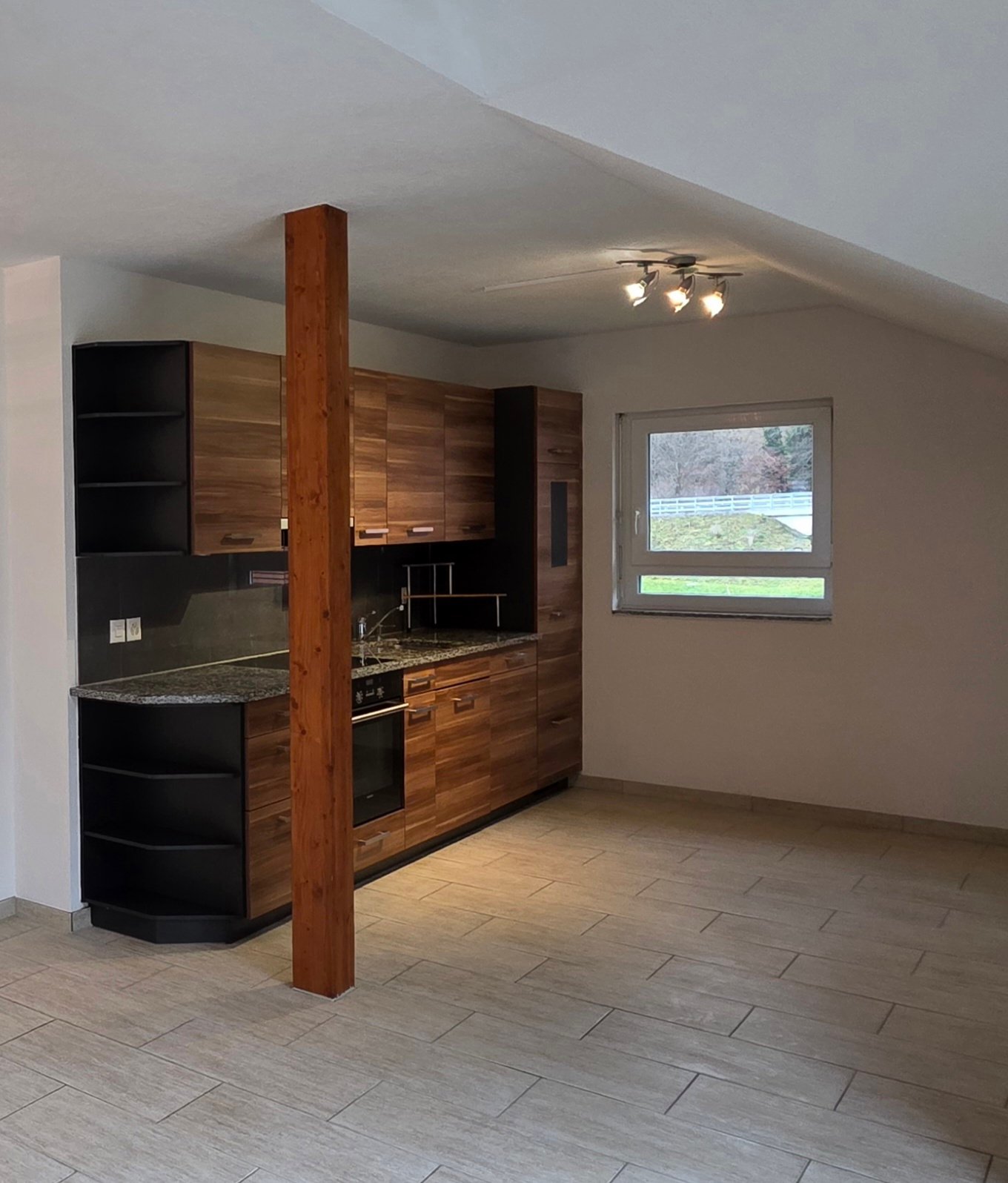 Kitchen with granite countertop, wooden cabinets, built-in oven, sink, window