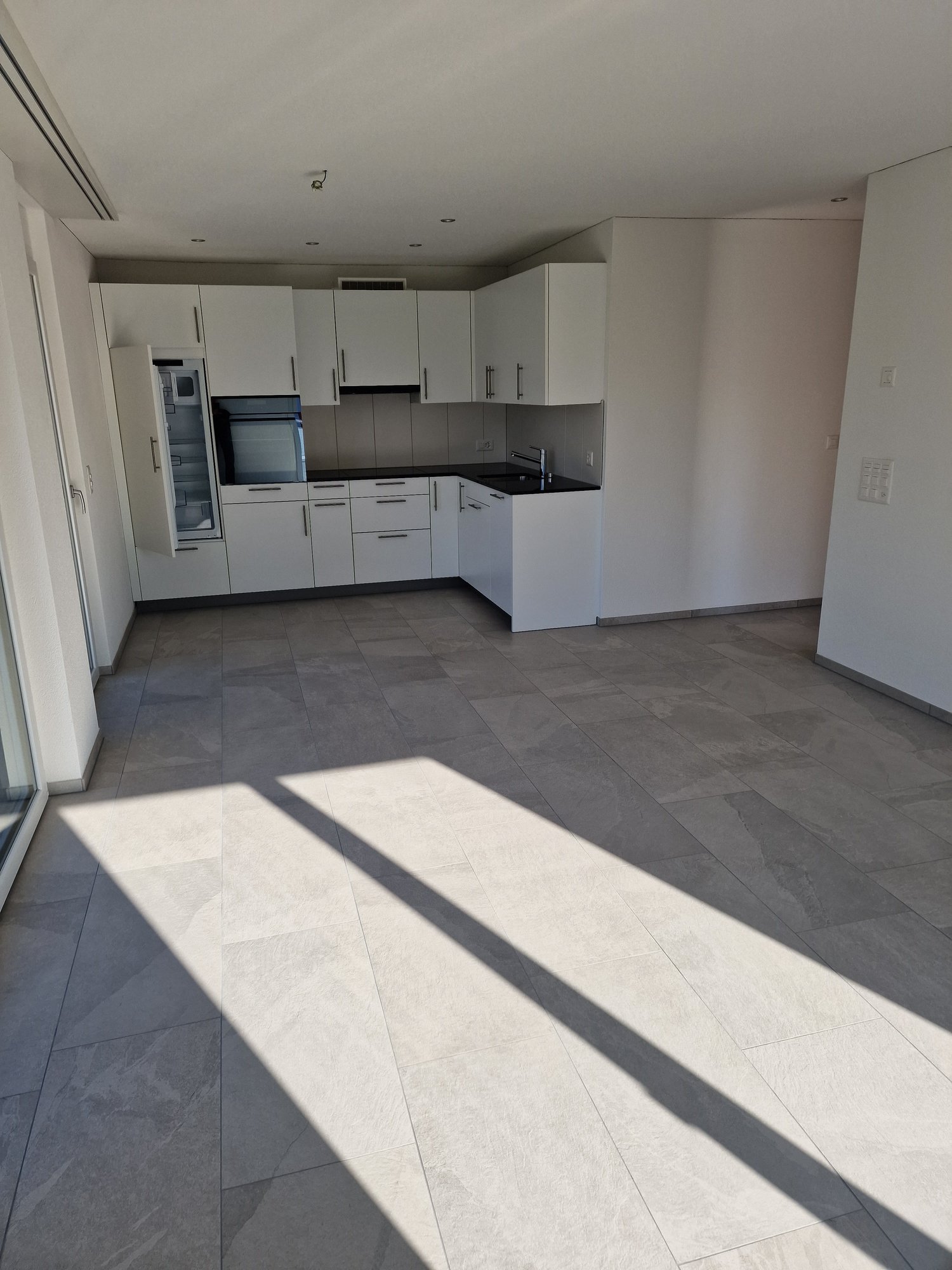 white cabinets, black countertops, silver faucet, white tiles, large glass windows