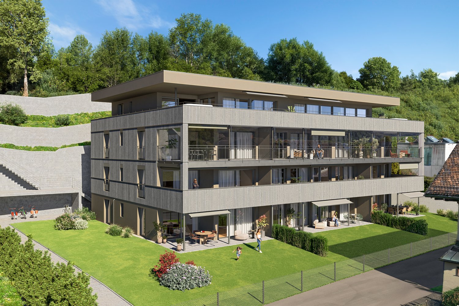 3-story modern apartment building with a flat roof, gray siding, and large windows. The building has balconies on each floor and a landscaped yard with a paved parking area in front.