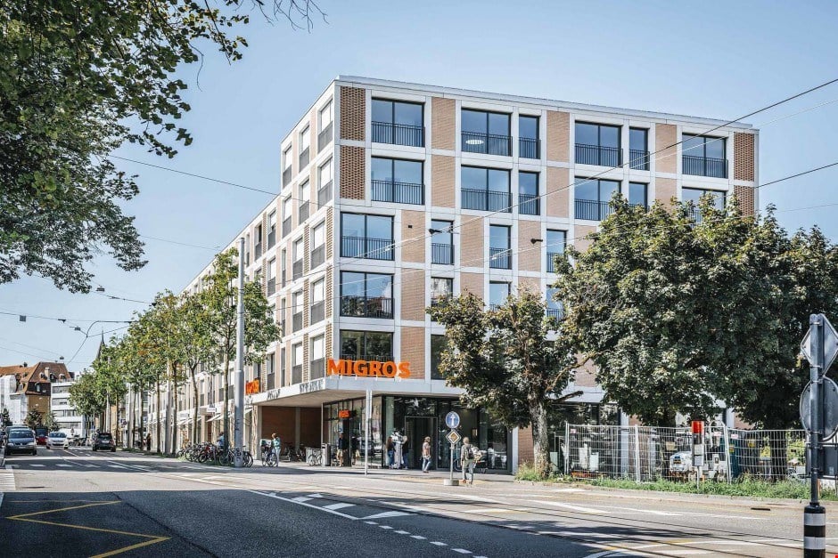 A tall building with glass windows and a storefront on the bottom floor