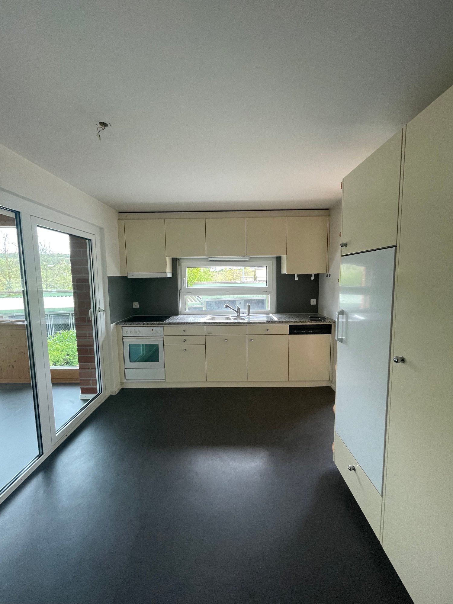 Kitchen with modern appliances and glass balcony doors