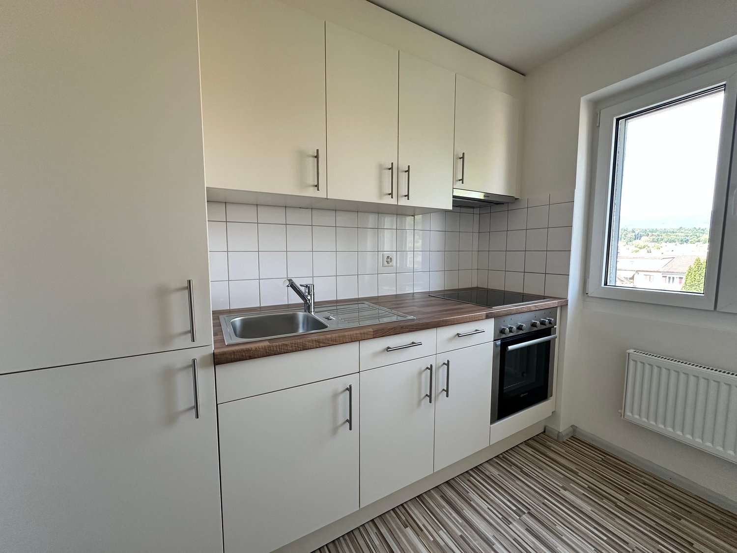 white cabinetry, wooden countertops, stainless steel sink, gas stove, oven, modern appliances, tile backsplash, window with view