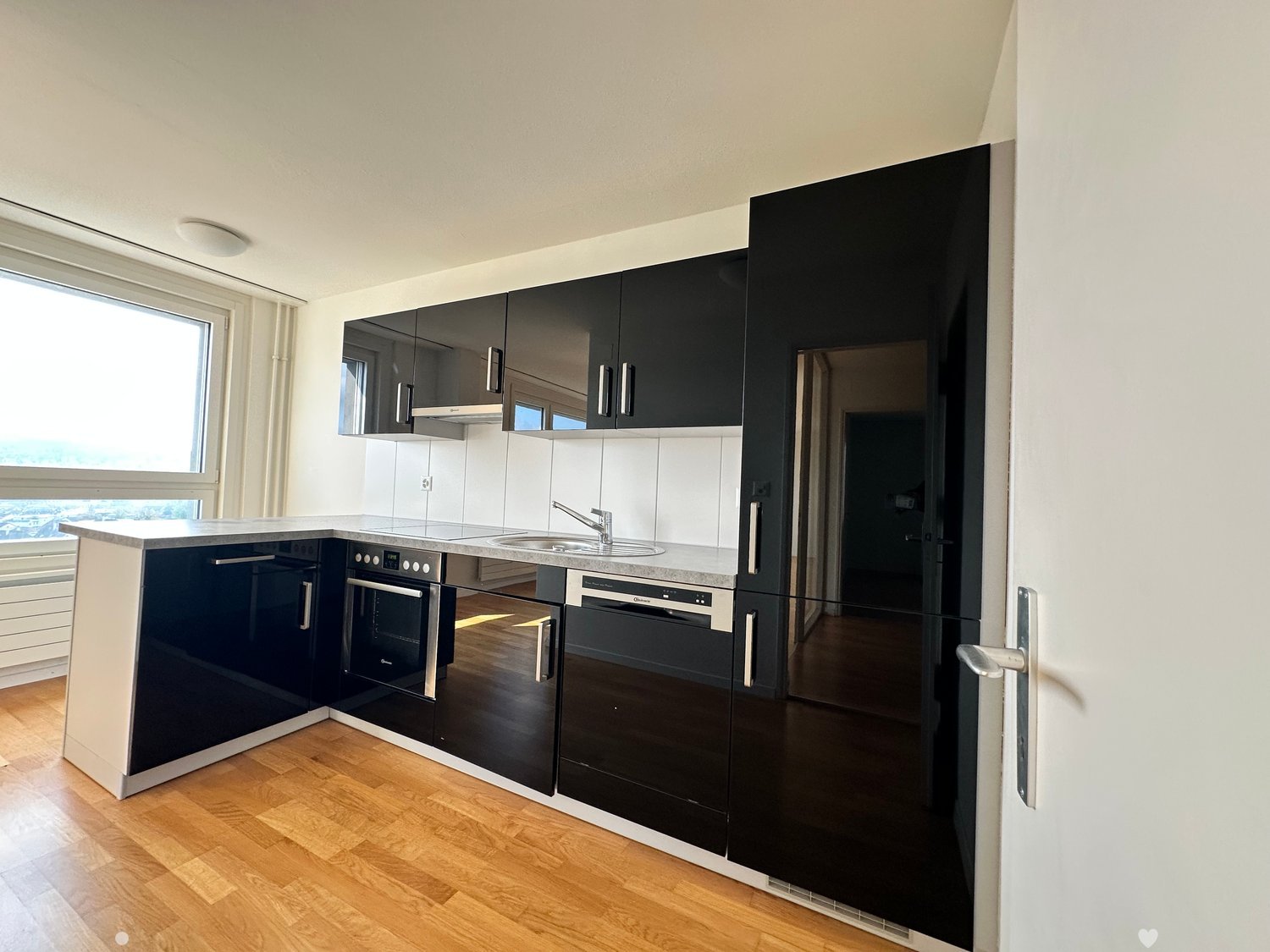 modern kitchen with black cabinets, granite countertop, stainless steel appliances, large window