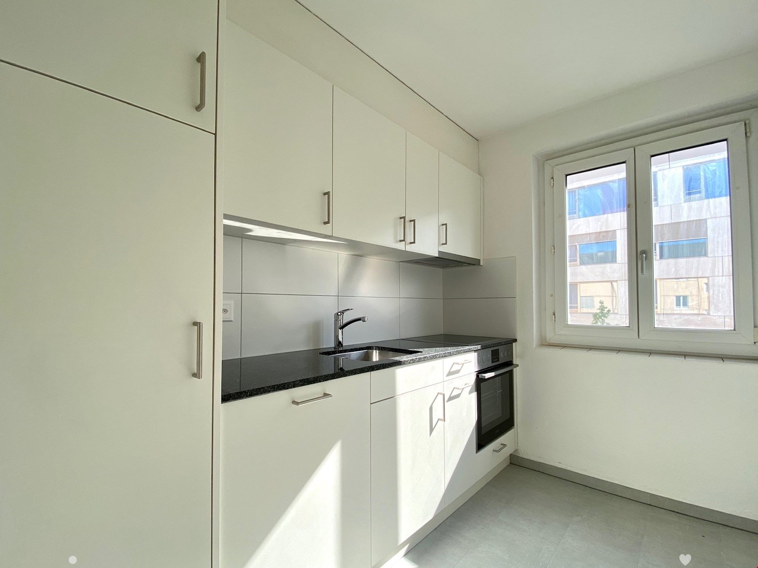white cabinets, countertop, integrated oven and microwave, double sink, silver faucet