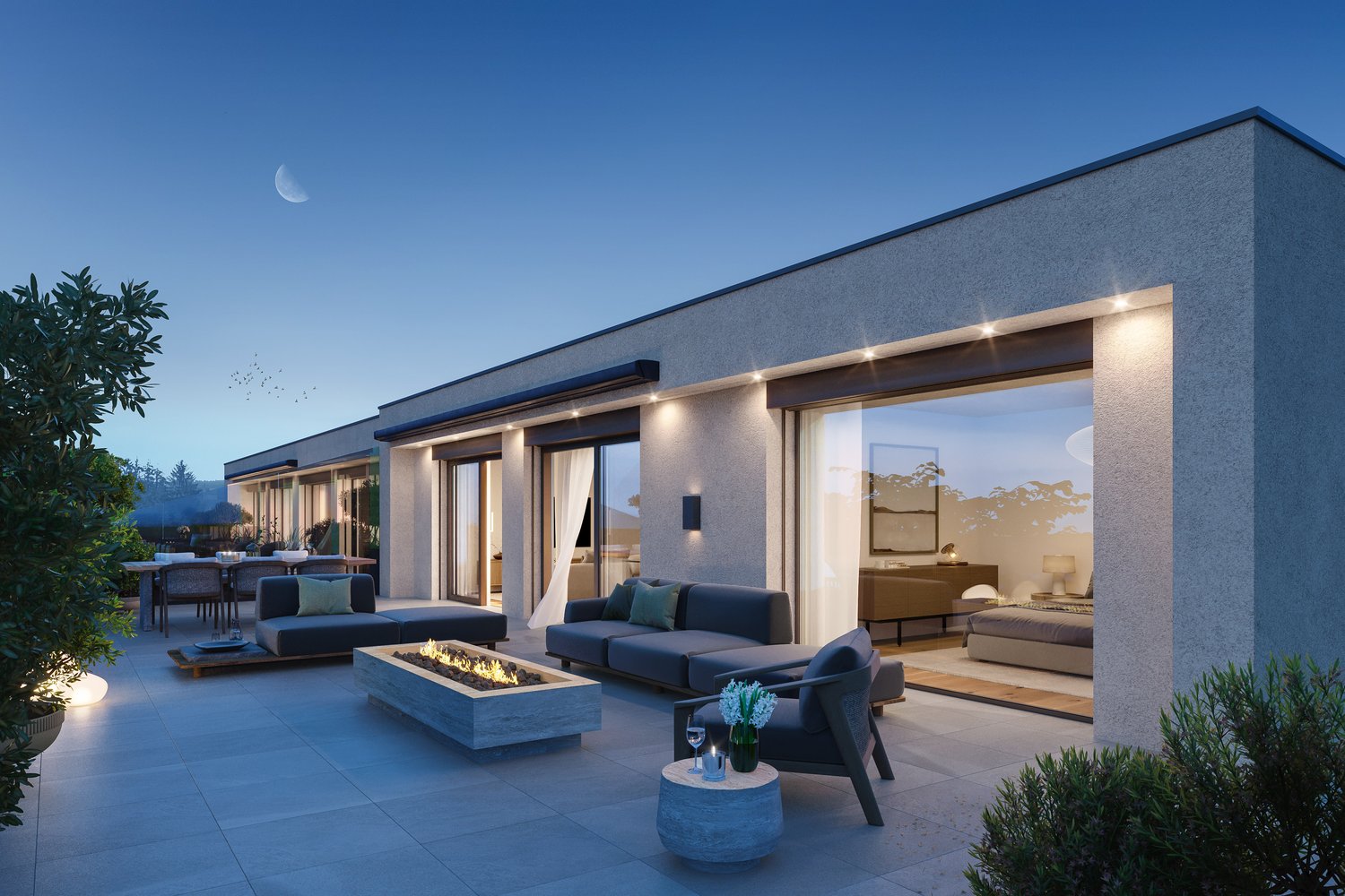 Modern two-story house with a large outdoor patio area, featuring a fireplace, comfortable seating, and sliding glass doors leading to the interior. The exterior has a sleek, contemporary design with a mix of materials including stone and wood. The night