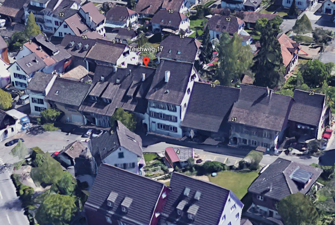 A collection of residential houses, Teichweg 17 marked by a red pin, brown roofs, white walls, driveways, trees, and a road