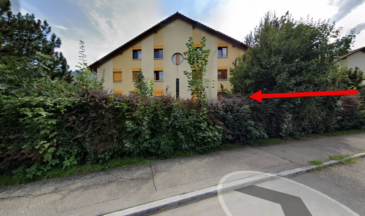 3-story house with beige walls and brown roof, 6 windows, red arrow pointing to entrance.